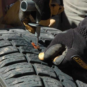 A person using a tool to repair a tire.